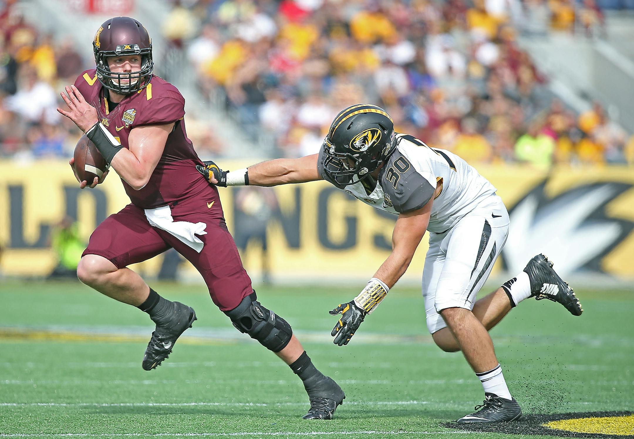 Minnesota's quarterback Mitch Leidner (7) ran for yards despite pressure from Missouri's linebacker Michael Scherer (30) during the first quarter of the Citrus Bowl at Citrus Bowl Stadium, Thursday, January 1, 2015 in Orlando, FL.