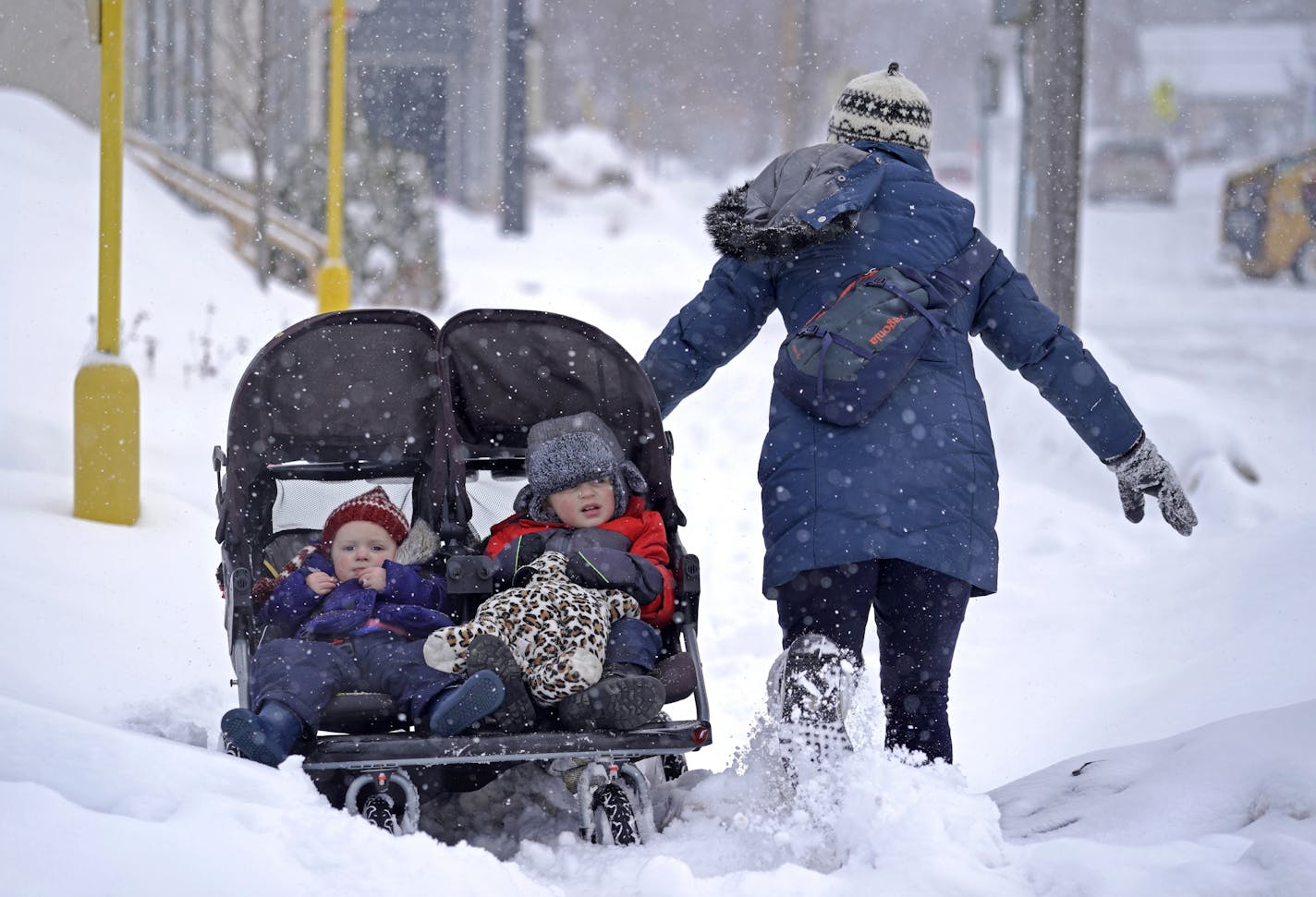 Mari Melby's quick trip to the doughnut shop, near 55th and Lyndale Ave. S., with her children Gwen, 1 and Theo,3, turned treacherous after the heavy snow complicated her trip two blocks back home with a double stroller. Melby kept a good attitude and said "It was a good workout."