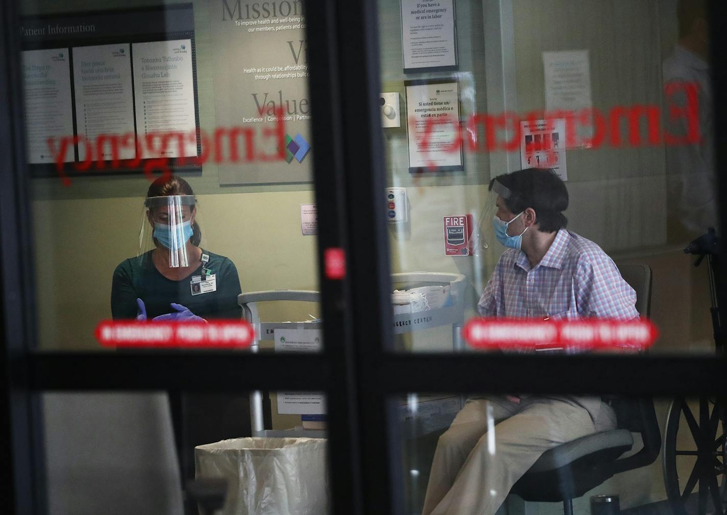 Screeners wait inside the entrance to the Park Nicollet Methodist Hospital emergency room, where they check those arriving for COVID symptoms before determining where they will go within the hospital and seen Thursday, June 4, 2020, in St. Louis Park, MN.