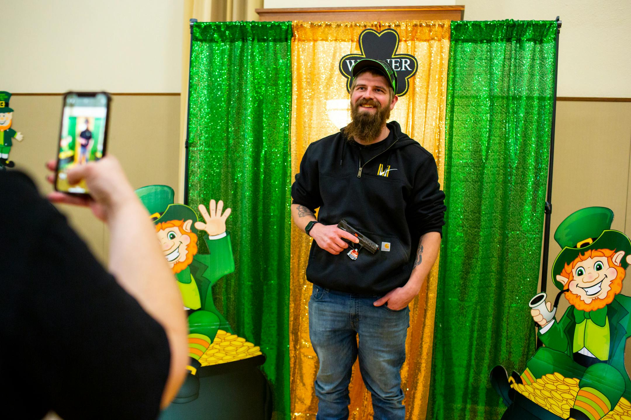 Matt Johnson poses with his new Taurus TX22 pistol during Designer Purse & Gun Bingo, a fundraiser for Glencoe Days.