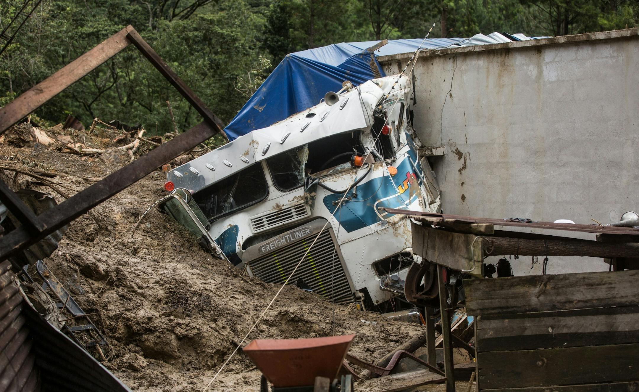 A semi is partially buried in a massive, rain-fueled landslide in the village of Queja, in Guatemala, Saturday, Nov. 7, 2020, in the aftermath of Tropical Storm Eta.