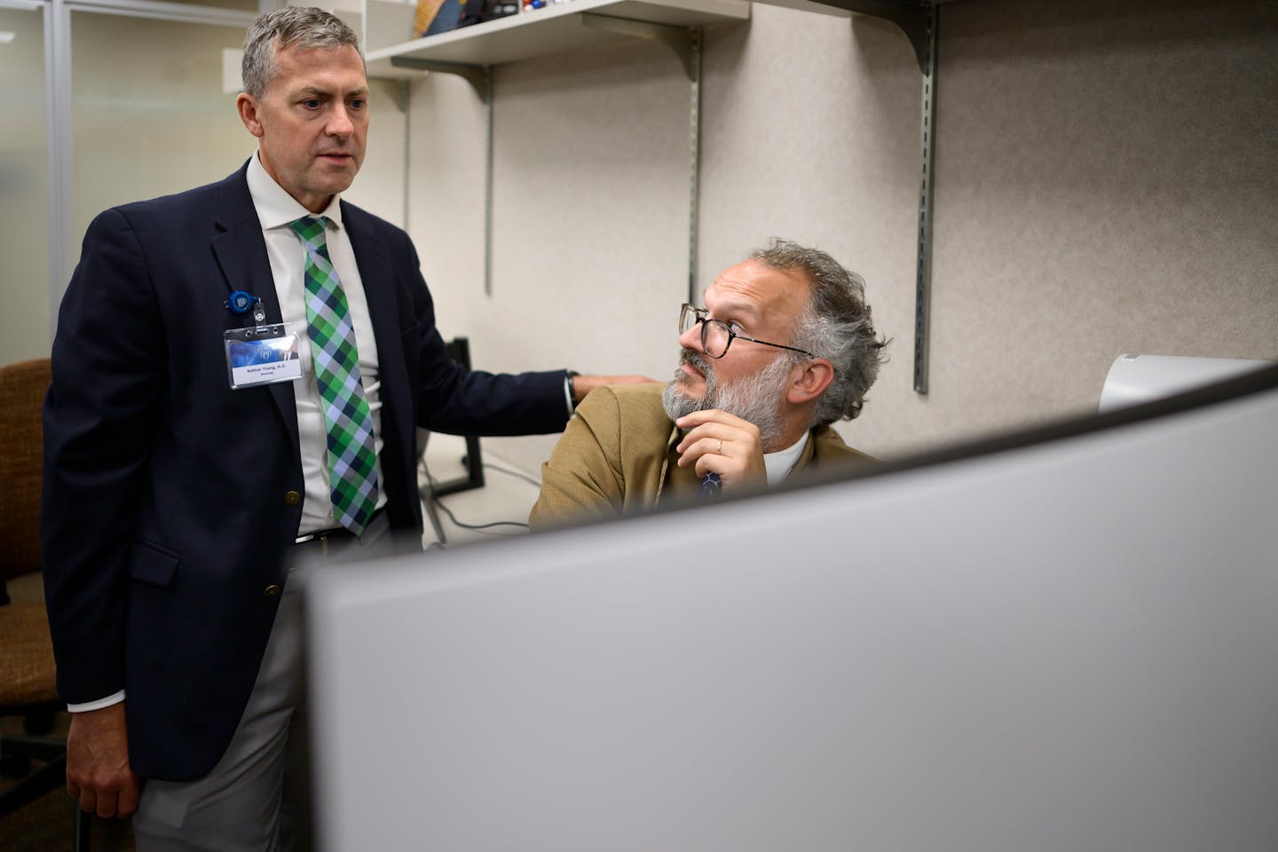 Drs. Nathan Young, left, and David Jones, Mayo Clinic neurologists, look over PET scans utilizing the hospital system’s StateViewer AI software.