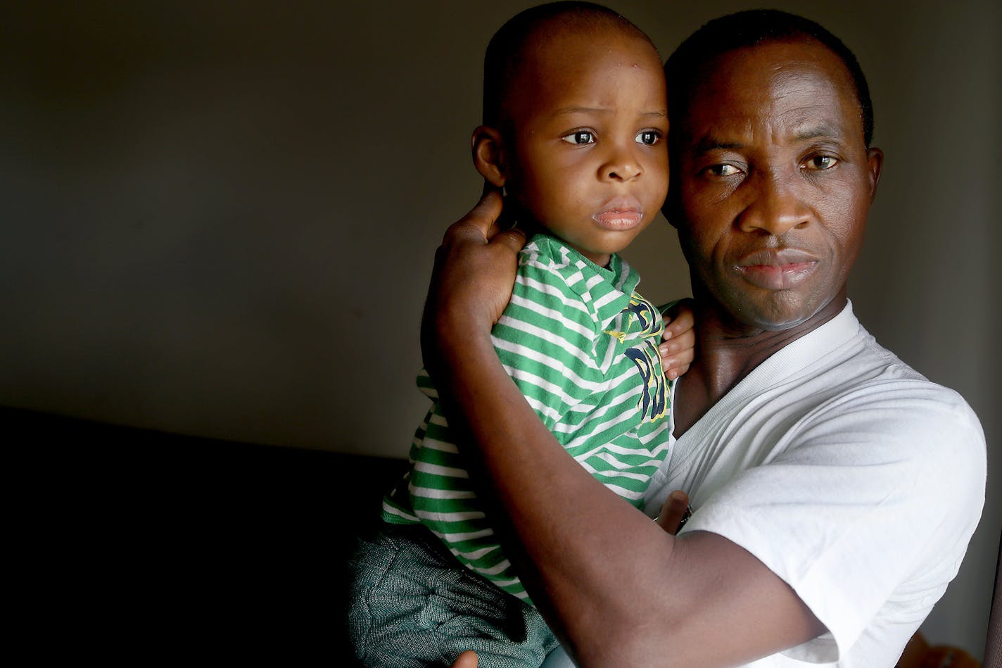 James Tuan held his 2-year-old son Jamel at his home in Brooklyn Center. Tuan and his girlfriend are from Liberia and have Temporary Protected Status, a program that is expiring in May.