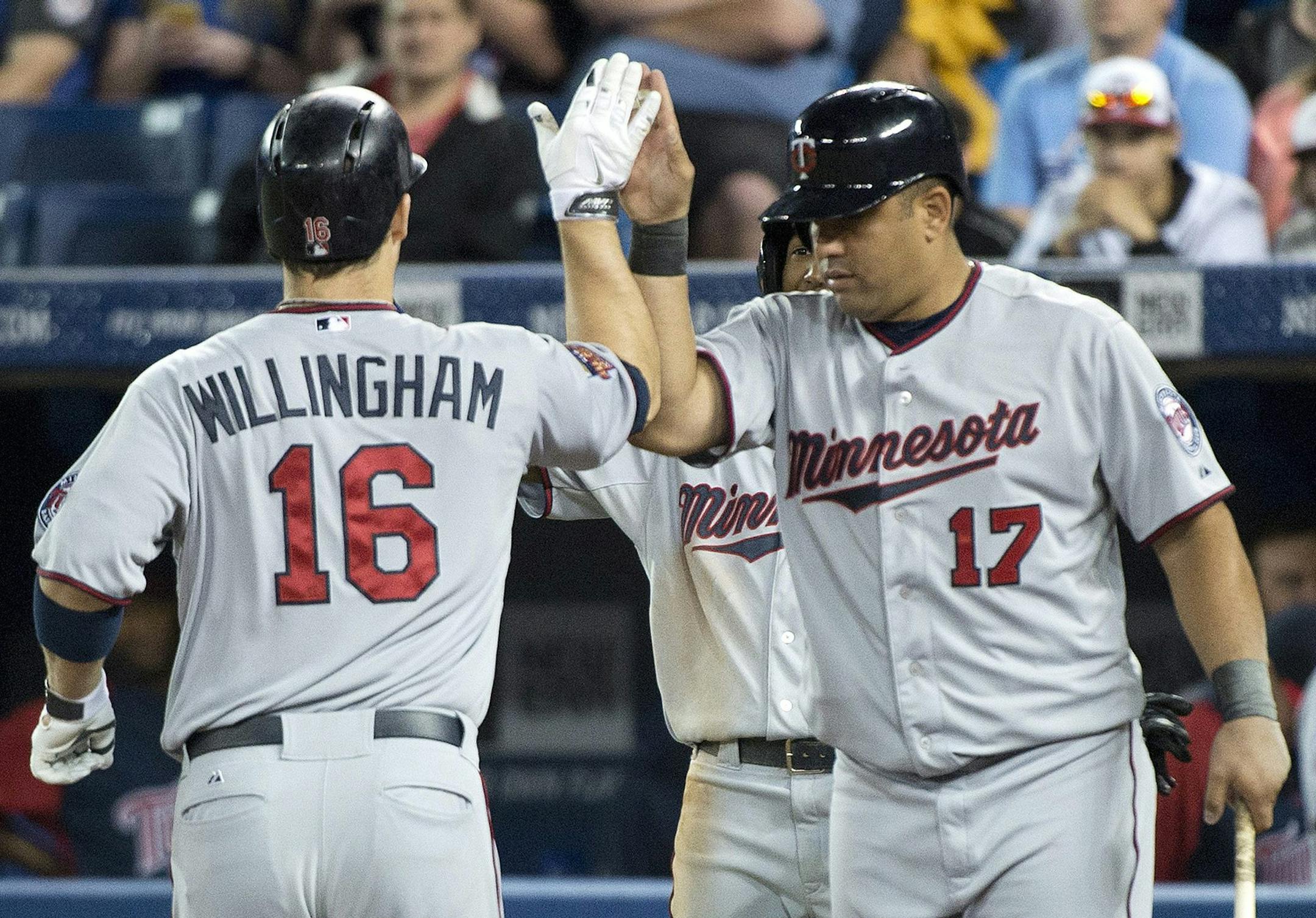 Minnesota Twins Josh Willingham (16) celebrates with teammate Kendrys Morales (17) after hitting a two-run home run against the Toronto Blue Jays during the first inning of a baseball game in Toronto on Wednesday, June 11, 2014. (AP Photo/The Canadian Press, Nathan Denette)