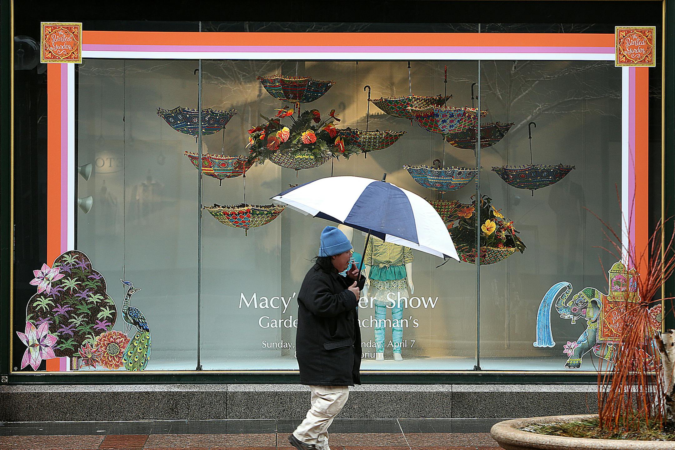 Anthony Xiong used an umbrella to protect himself from sleet and rain as he walked past a colorful display window on Nicollet Mall. ] (JIM GEHRZ/STAR TRIBUNE) / April 9, 2013 / 12:00 PM Minneapolis, MN