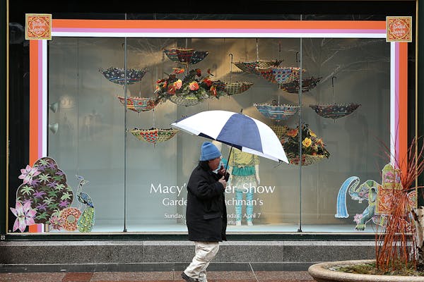 Anthony Xiong used an umbrella to protect himself from sleet and rain as he walked past a colorful display window on Nicollet Mall. ] (JIM GEHRZ/STAR 