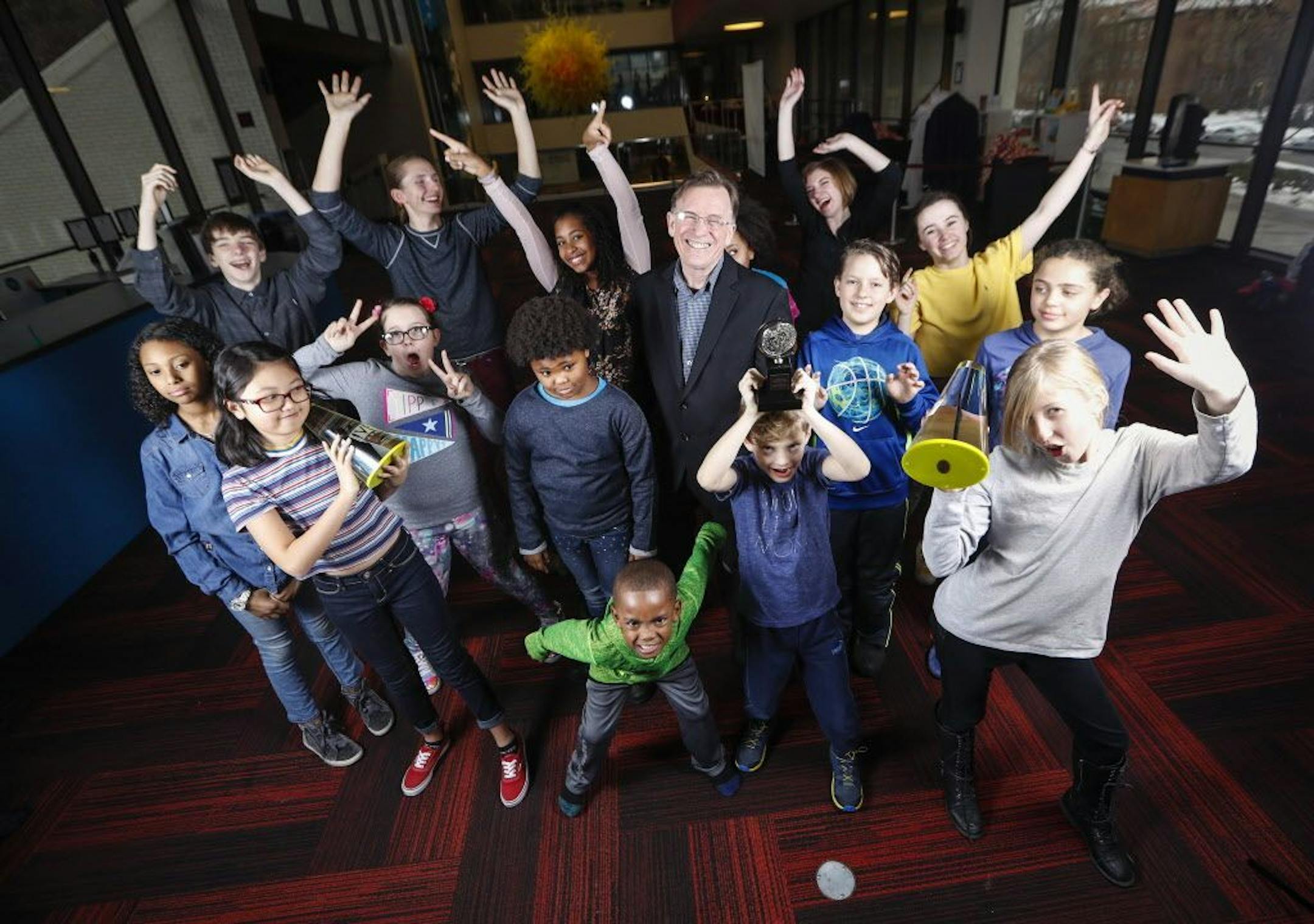 Children's Theatre artistic director Peter Brosius posed for a picture with a group of children, some holding his Ivy and Tony awards, who are part of the Children's Theatre.