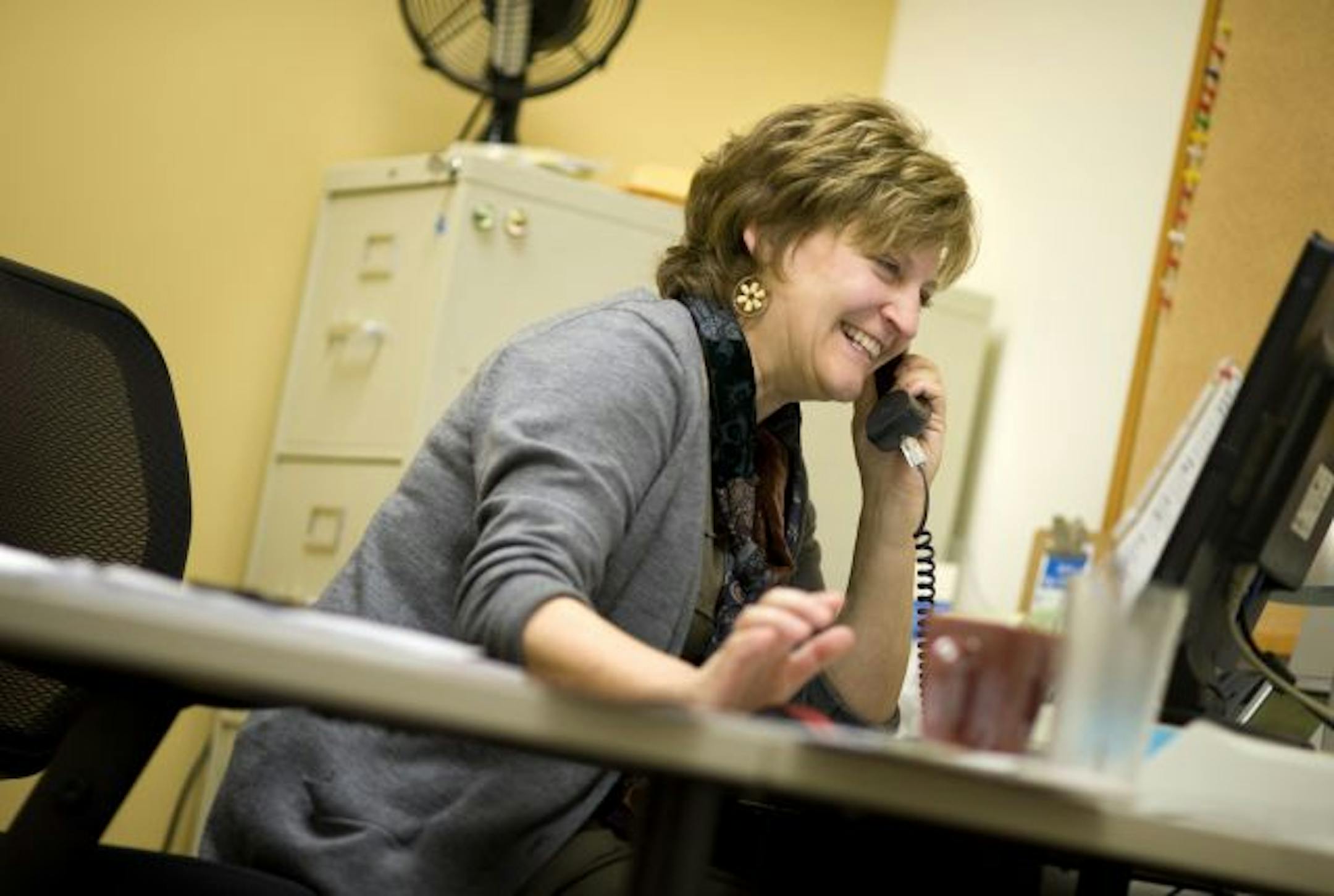 Still conducting business on her last day of work after 27 years as the general manager of Arc's Value Village stores, Erin Geiser helped with some work issues and then joked around with Arc Value Village facilities manager.