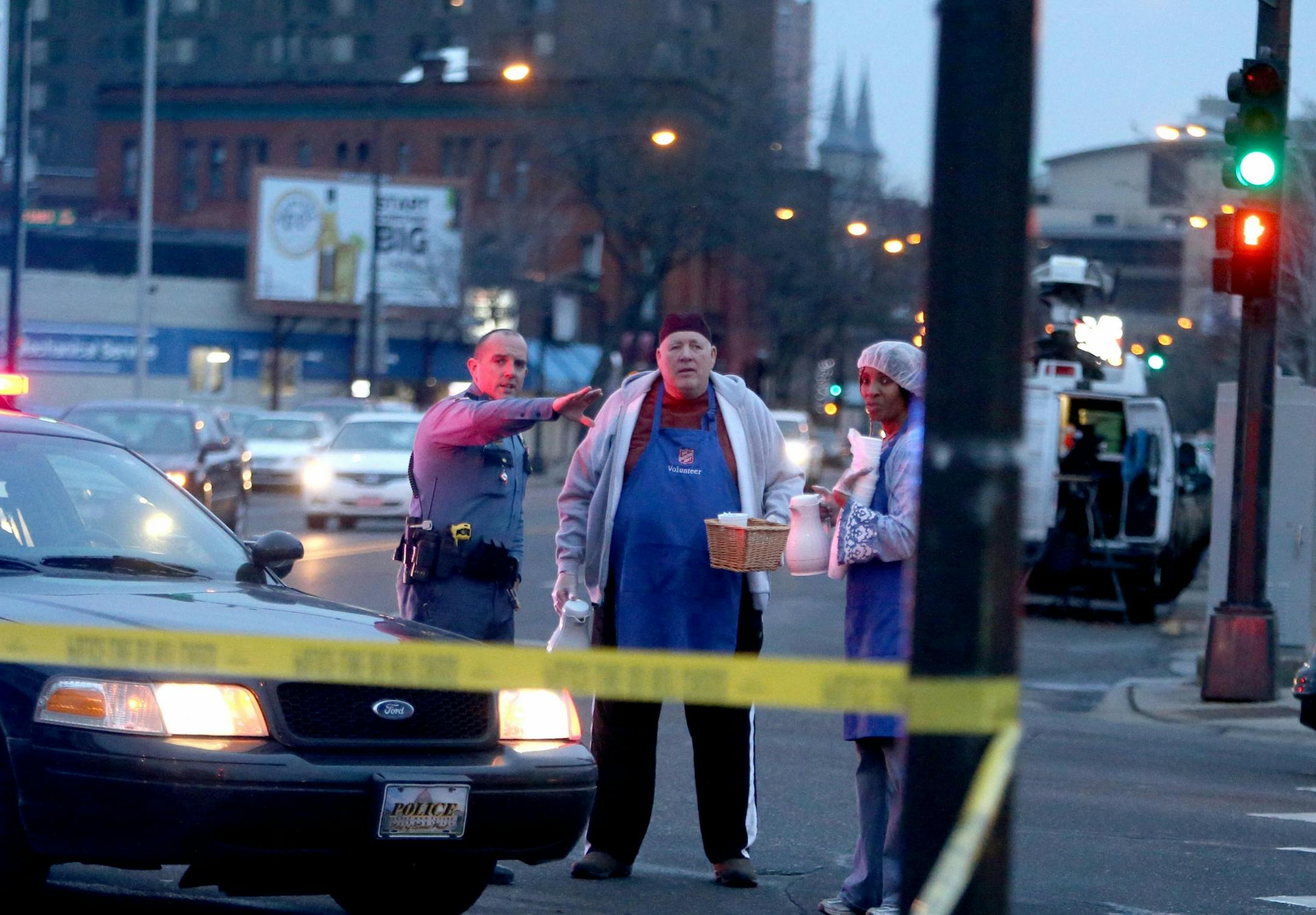 Scene of an early morning homicide where two persons are dead and a third critically wounded near the Salvation Army at 7th St and Smith Ave. Thursday, Dec. 10, 2015, in St. Paul, MN. Herea Salvation Army volunteers Regina Shoecraft, right to left, and Rod Aslesen speak to St. Paul Police officer Reetz as they try to get coffee out to the homeless and to police officers on the scene.