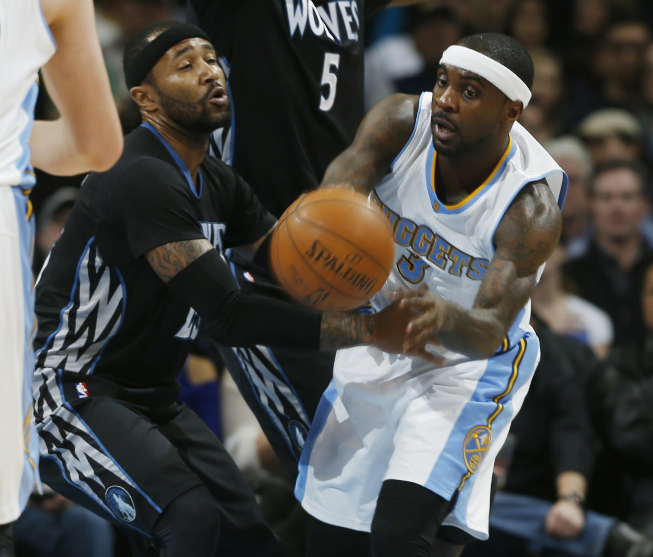 Minnesota Timberwolves guard Mo Williams, left, attempts to steal the ball from Denver Nuggets guard Ty Lawson in the first quarter of an NBA basketball game Saturday, Jan. 17, 2015, in Denver. (AP Photo/David Zalubowski)