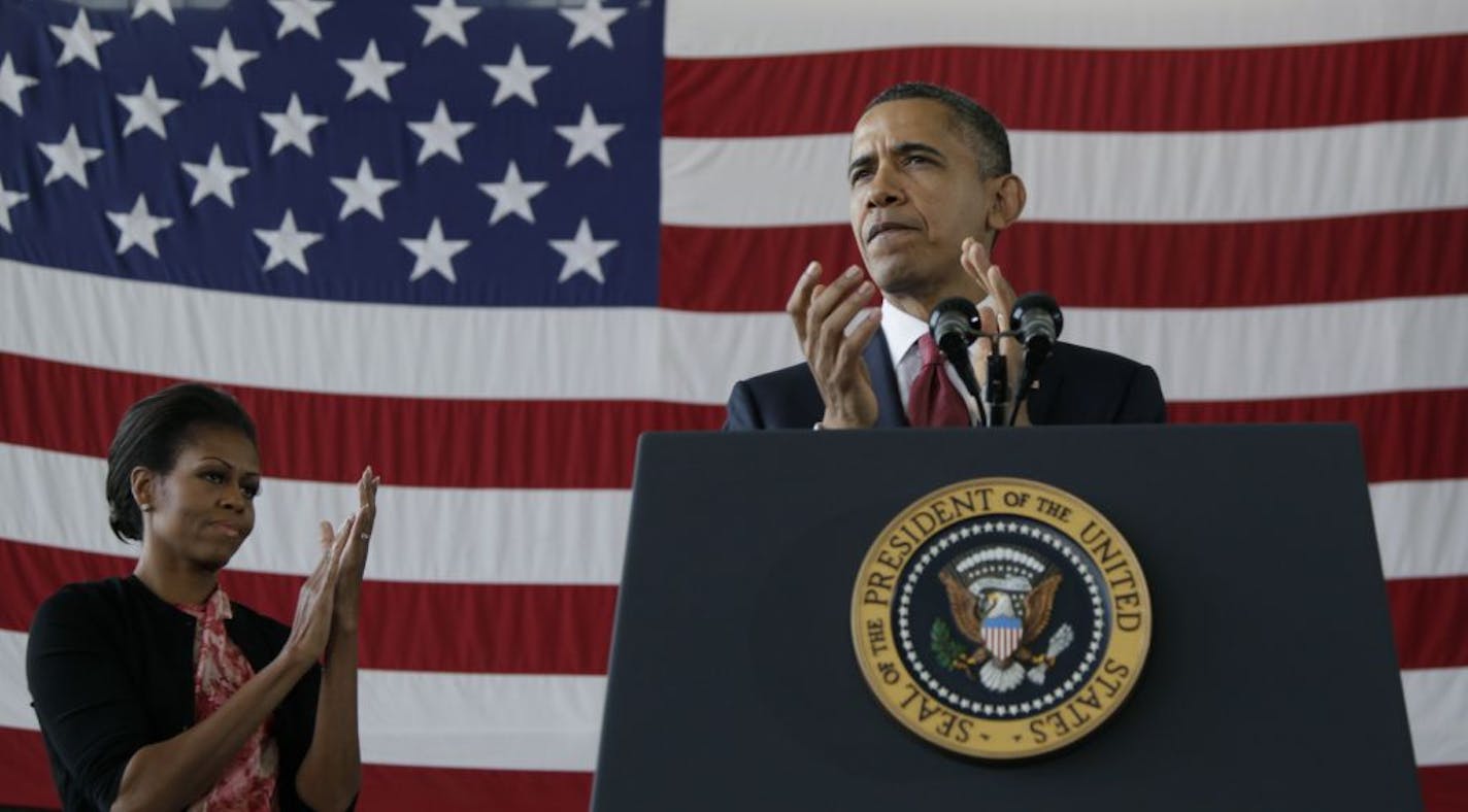 President Barack Obama and first lady Michelle Obama applaud the troops during their visit to Fort Bragg, N.C., Wednesday, Dec. 14, 2011.