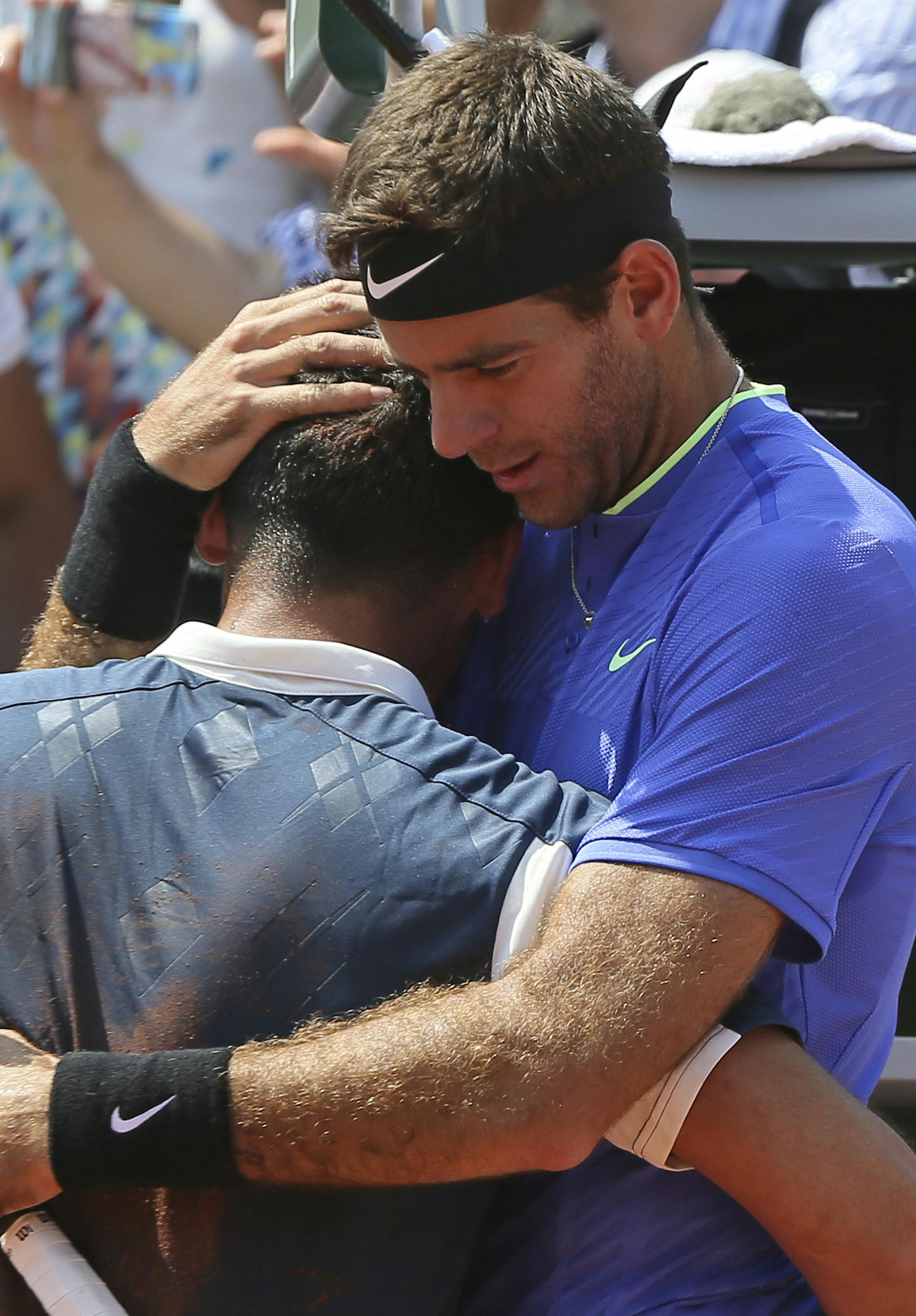 Spain's Nicolas Almagro, left, is comforted by Argentina's Juan Martin del Potro after he collapsed with a left knee injury in his second round match against at the French Open tennis tournament at the Roland Garros stadium, in Paris, France. Thursday, June 1, 2017. Almagro was unable to continue to play. (AP Photo/David Vincent)