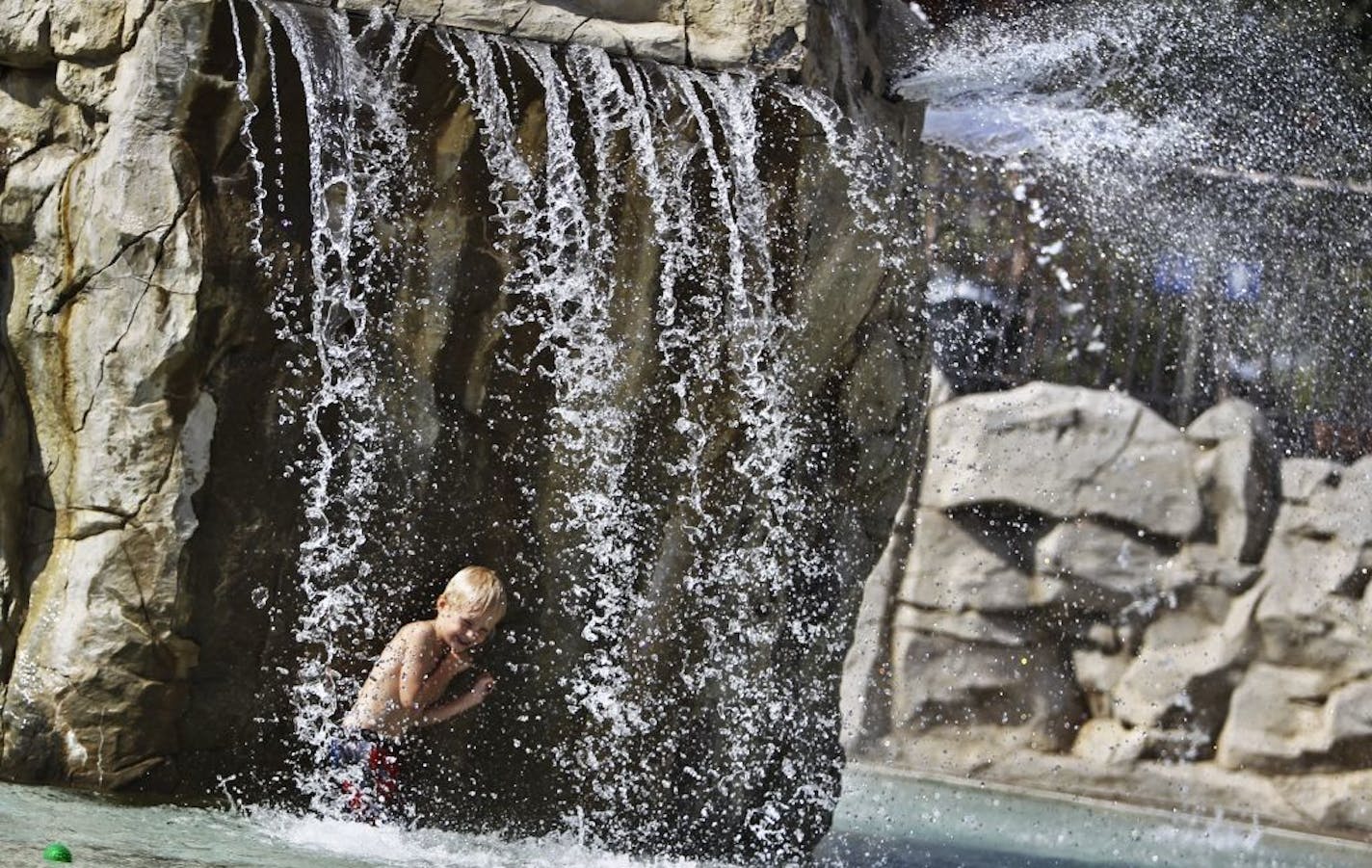 High winds blew the water around at North Mississippi Regional Park wading pool Tuesday, Sept. 11, 2012, as Finn Jorgensen, 3, stayed cool under the pool's waterfall. Jorgensen was playing with his friend Sam Snyder (not pictured). Together the friends and neighbors will turn 4 together on Sept. 19. Two wading pools remain open this summer until Sept. 16, including North Mississippi Regional Park and Wabun Park, according to a Minneapolis Park and Recreation Board website.