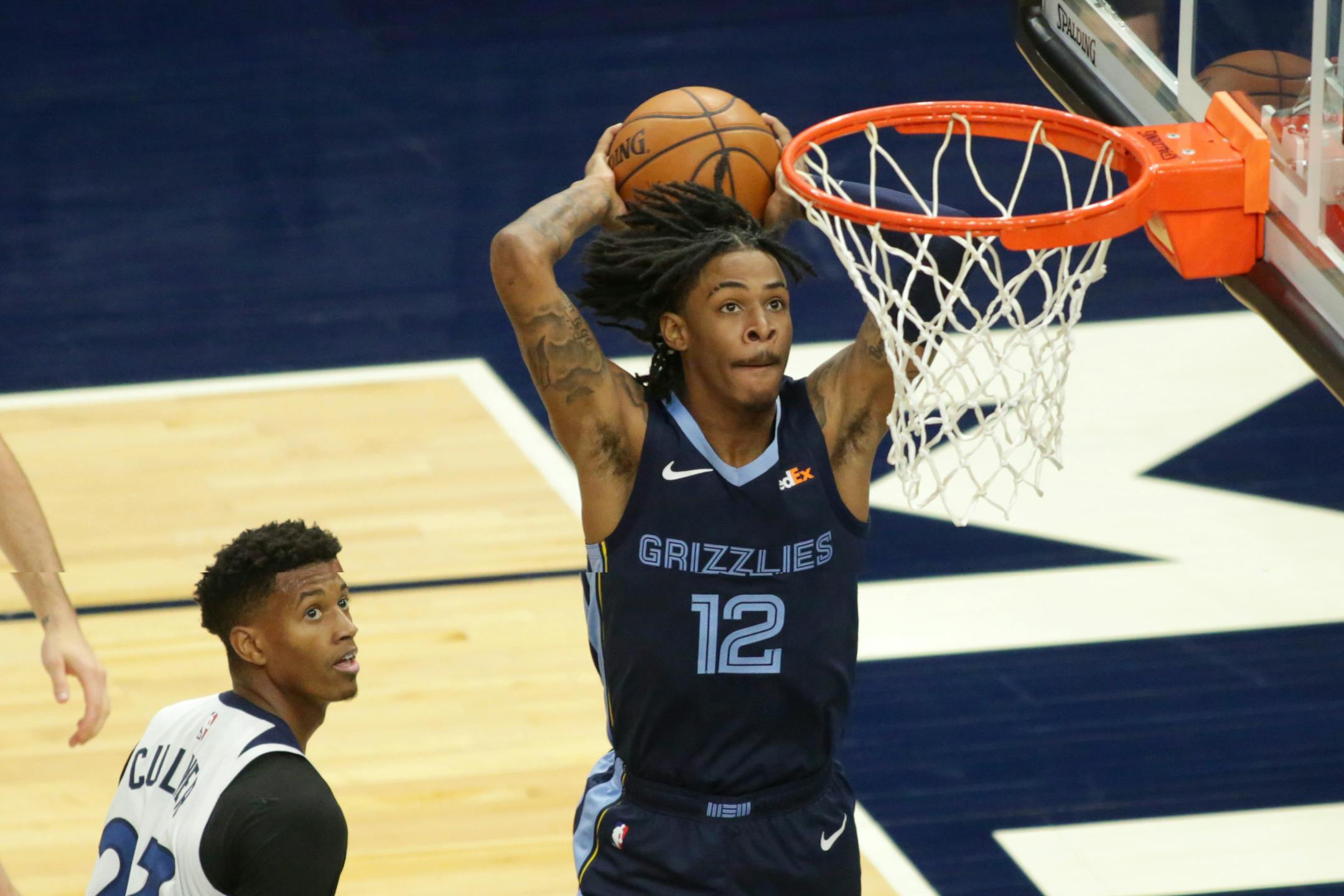 Memphis Grizzlies guard Ja Morant (12) dunks in front of Minnesota Timberwolves Jarrett Culver (23) in the third quarter during an NBA preseason basketball game, Saturday, Dec. 12, 2020, in Minneapolis. (AP Photo/Andy Clayton- King)