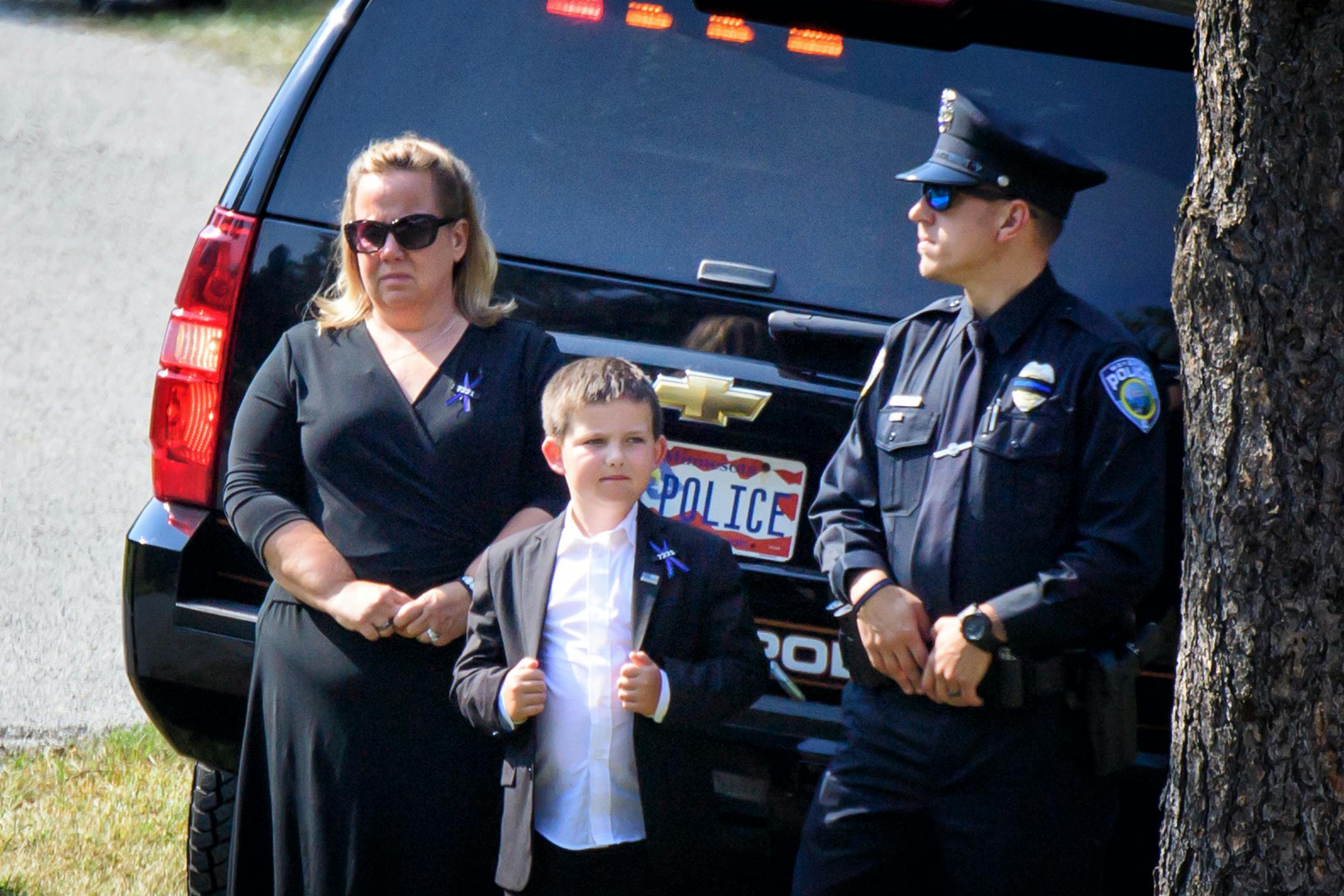 Shawn Mathews and her son, Wyatt, wait for her husband William Mathews' casket to arrive for burial ceremony at Summit Park Cemetery.