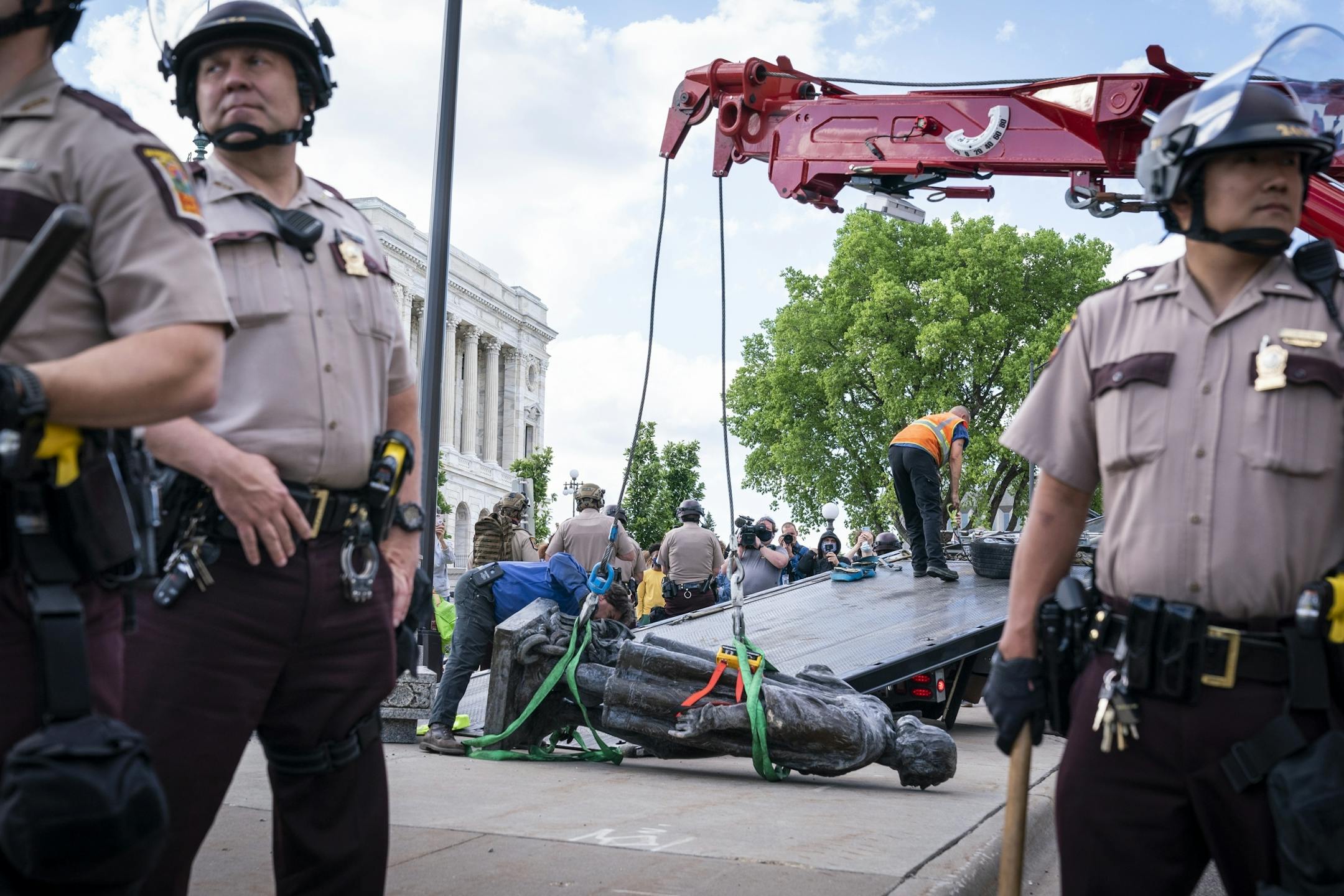 Minnesota State Troopers surrounded a statue of Christopher Columbus as it was taken away June 10 by a tow truck. It was toppled by protesters at the State Capitol.