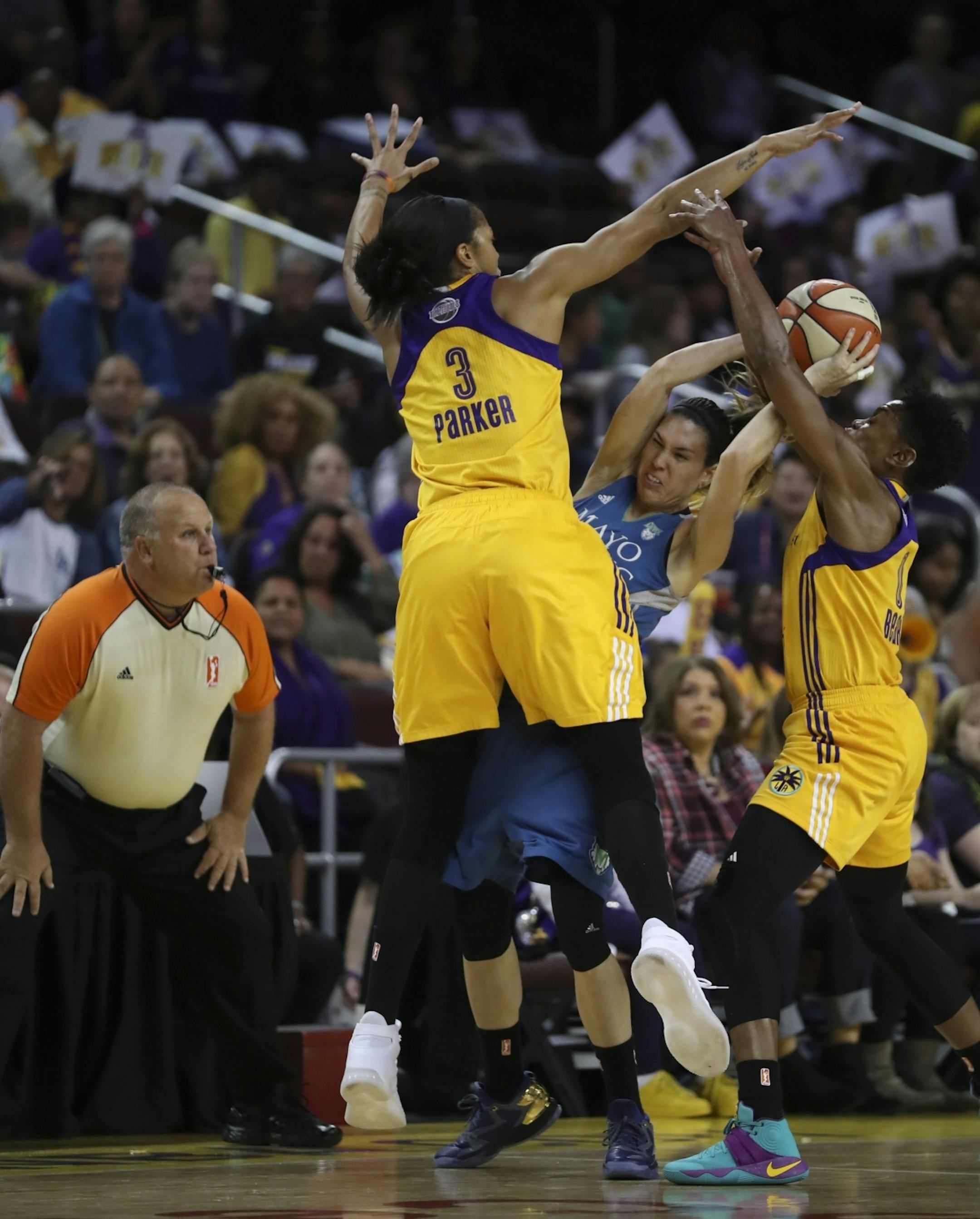 Minnesota Lynx guard Anna Cruz (51) was defended hard by Los Angeles Sparks forward Candace Parker (3) and guard Alana Beard (0) in the first quarter.