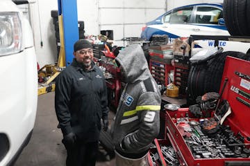 Mechanic Jesus Montes jokes with a driver while replacing the battery on his fleet vehicle Wednesday at Blue & White Cab in St. Louis Park.