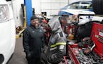Mechanic Jesus Montes jokes with a driver while replacing the battery on his fleet vehicle Wednesday at Blue & White Cab in St. Louis Park.