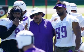 Vikings assistant head coach Andre Patterson talks to defensive tackle Sheldon Richardson, left, and defensive end Danielle Hunter at minicamp in June