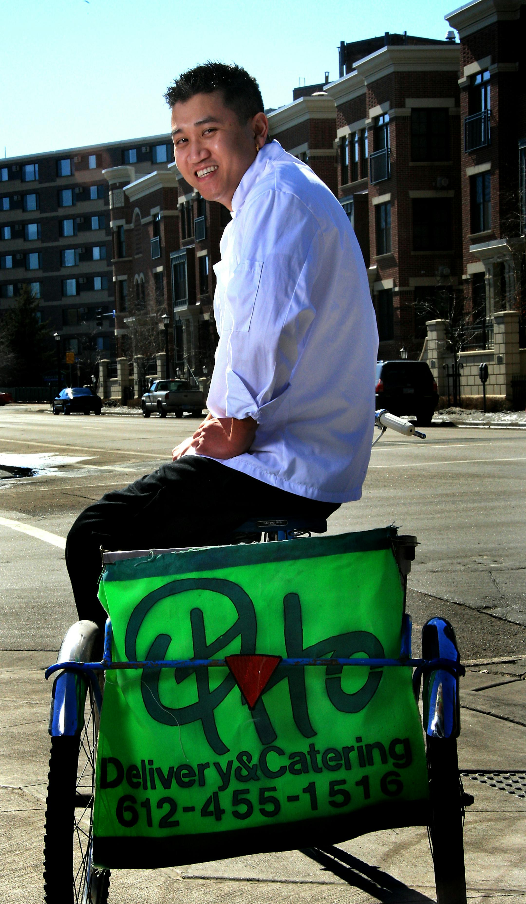 Otho Phanthavong, owner/chef, at Otho Restaurant & Street Lounge on the three-wheel bicycle that his staff uses to deliver the restaurant's food.