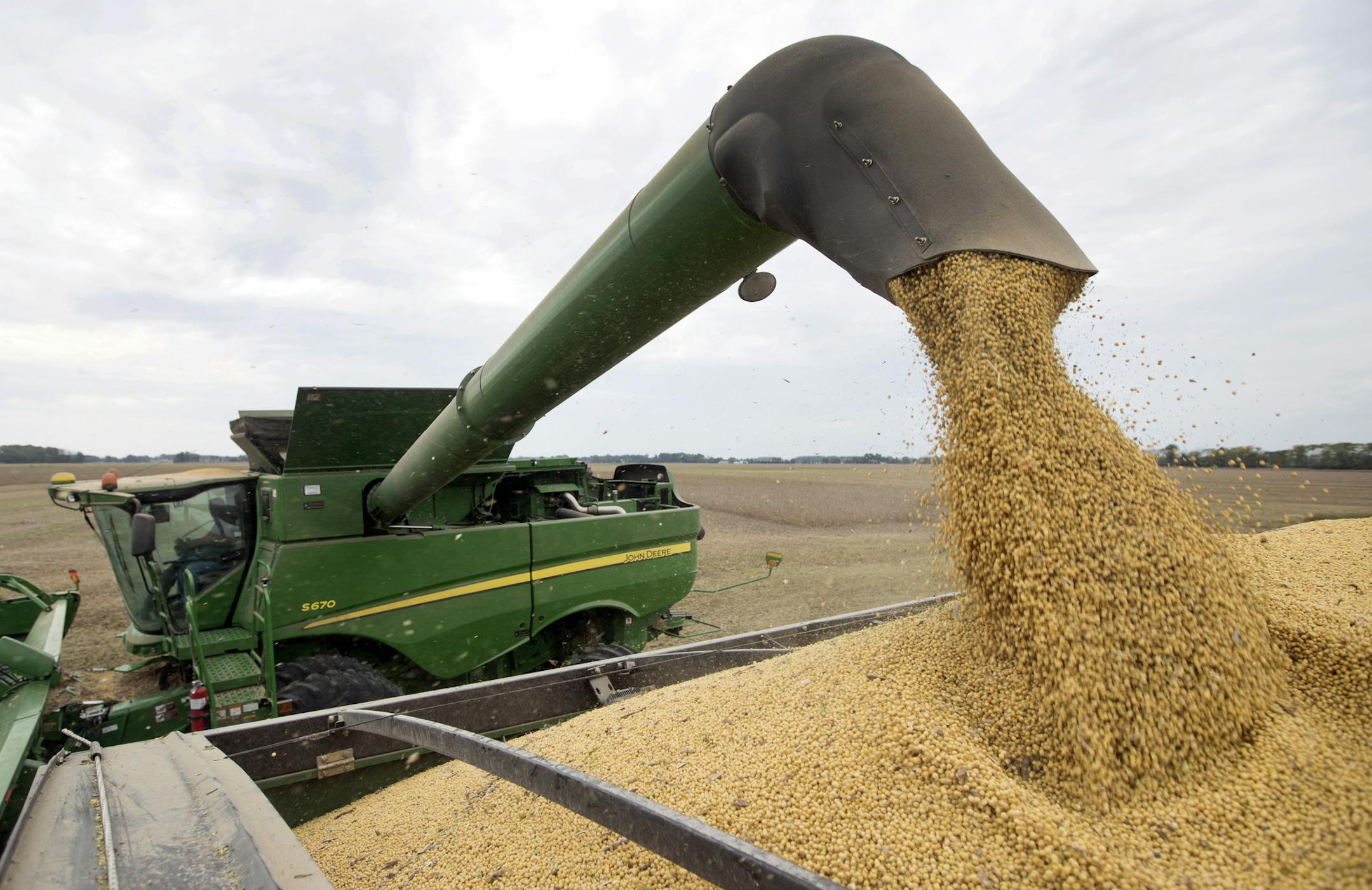 Mike Starkey offloads soybeans from his combine as he harvests his crops in Brownsburg, Ind., Friday, Sept. 21, 2018.The United States is scheduled to slap tariffs on $200 billion in Chinese imports Monday, adding to the more than $50 billion worth that already face U.S. import taxes. China has vowed to counterpunch with tariffs on $60 billion in U.S. goods. (AP Photo/Michael Conroy)