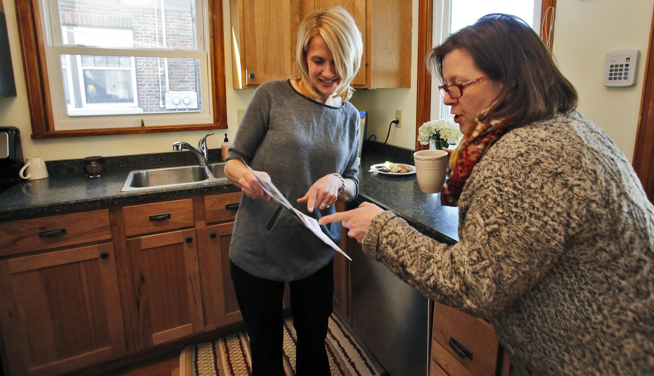 Marcy Wengler is a real estate agent in St. Paul who has found difficulty selling houses this winter due to the harsh weather conditions. She has responded by making cookies and coffee for those that endure the snow and cold to tour her sale homes. Tracy Oxford, St. Paul, right, drank a cup of coffee as she talked with Wengler in a St. Paul home. (MARLIN LEVISON/STARTRIBUNE(mlevison@startribune.com)