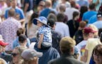 Eddie Hoeschen, 2, rode on his grandpa Kevin Hoeschen's, of Duluth, shoulders as they walked through a thick crowd at the Minnesota State Fair in Falc