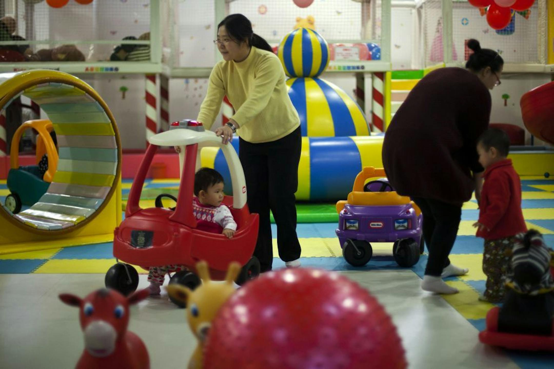 FILE - In this Jan. 10, 2013 photo, parents play with their children at a kid's play area in a shopping mall in Beijing. China will loosen its decades-old one-child policy and abolish a much-criticized labor camp system, its ruling Communist Party said Friday, Nov. 15, 2013. The official Xinhua News Agency said the party announced the changes in a policy document following a key, four-day meeting of party leaders that ended Tuesday in Beijing.