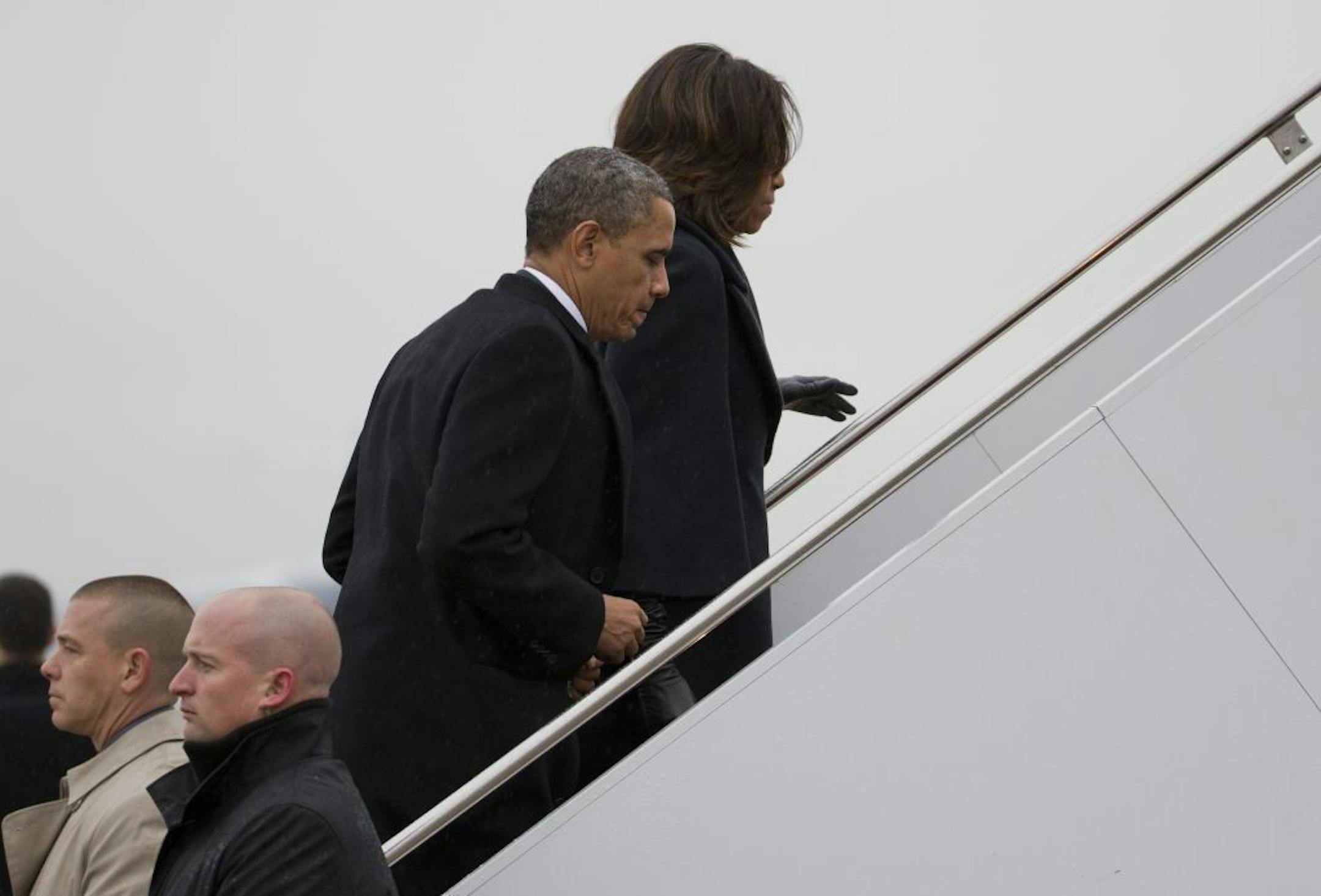 President Barack Obama and first lady Michelle Obama board Air Force One to travel to South Africa for a memorial service in honor of Nelson Mandela on Monday, Dec. 9, 2013 in Andrews Air Force Base, Md.