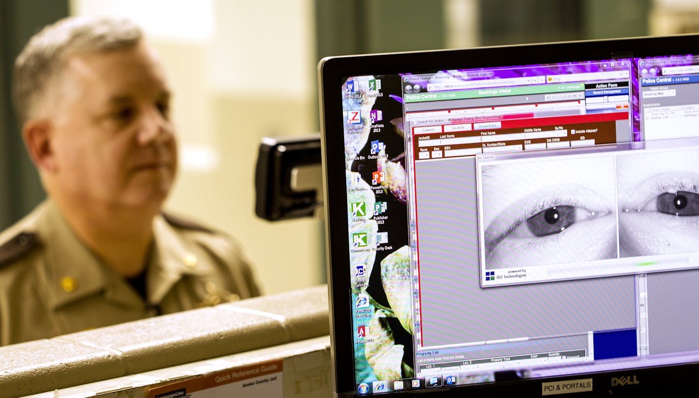 Anoka County Jail Commander Dave Pacholl demonstrates how a new iris scanning system works in the release station at the Anoka County Jail October 13, 2015. The scan, which is simply a high-quality photograph, takes less time to obtain than fingerprints. (Courtney Perry/Special to the Star Tribune)