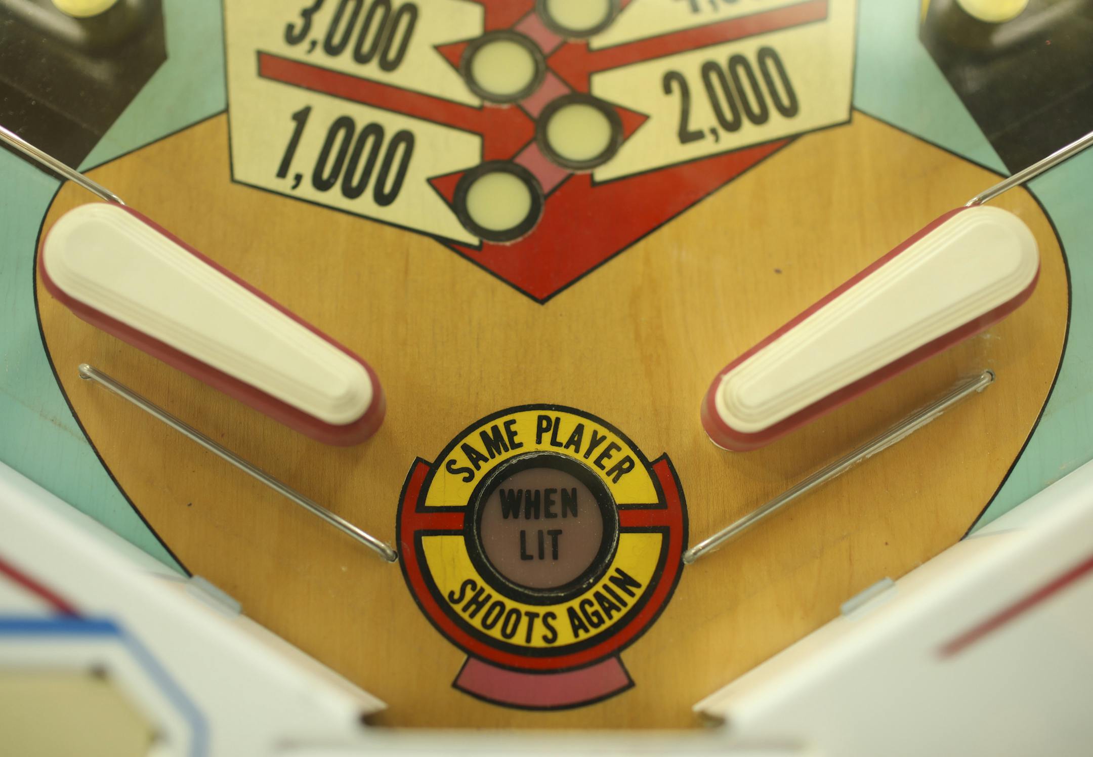 Detail of the flippers on a pinball machine. .