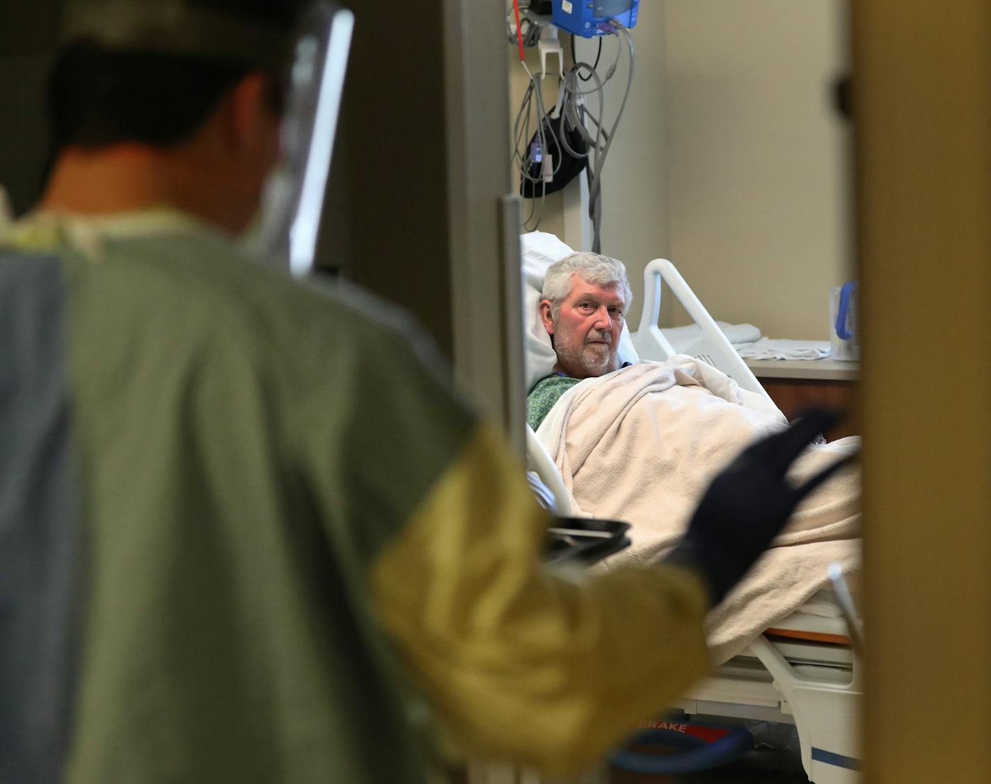 Jacob Evans, a traveling RN from Atlanta, visits recovering COVID-19 patient Ronald Buhrt, 79, of Cottage Grove on the fifth floor of Bethesda Hospital Thursday, May 7, 2020, in St. Paul, MN.] DAVID JOLES • david.joles@startribune.com Every time a COVID-19 patient leaves Bethesda Hospital alive, a bell rings throughout the St. Paul facility. Its a moral-booster for doctors and nurses -- as they struggle with a vexing disease, limited protective supplies, and the threat of many, many more cases t