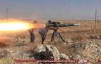 In this picture released on June 26, 2015, by a website of Islamic State militants, Islamic State militants fire an anti-tank missile in Hassakeh, nor
