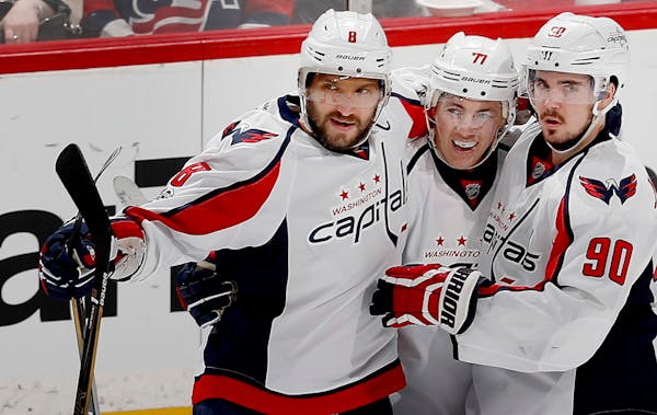 Washington's Alex Ovechkin, left, celebrated with teammates T.J. Oshie (77) and Evgeny Kuznetsov (90) after scoring a goal on a power play in the seco