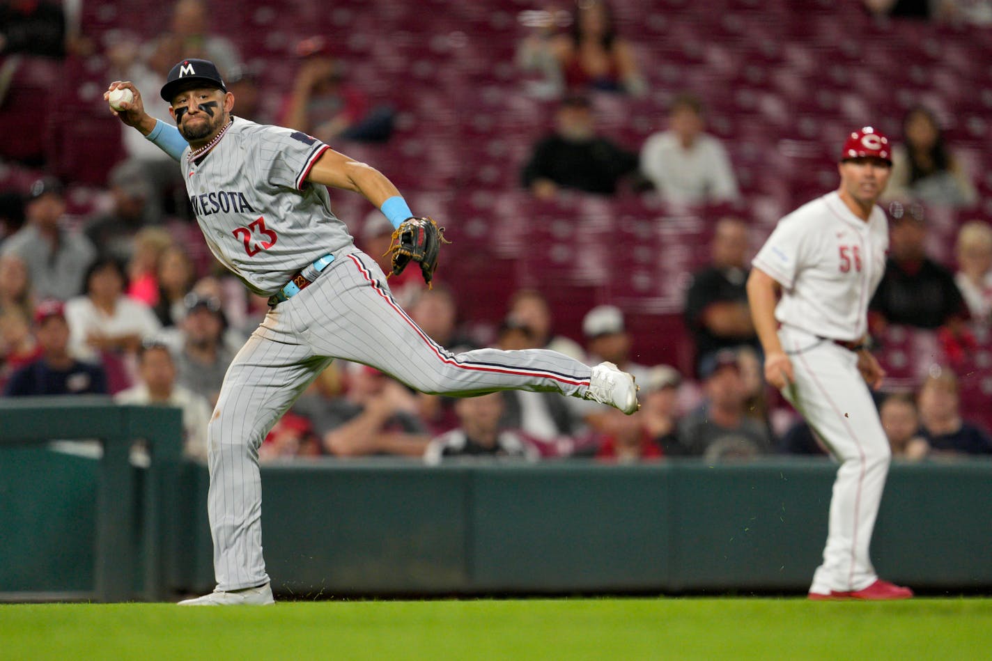 Minnesota Twins third baseman Royce Lewis (23) attempts to throw out Cincinnati Reds' Nick Senzel (not shown) at first base in the seventh inning of a baseball game in Cincinnati, Monday, Sept. 18, 2023. Senzel was safe on the play. (AP Photo/Jeff Dean)