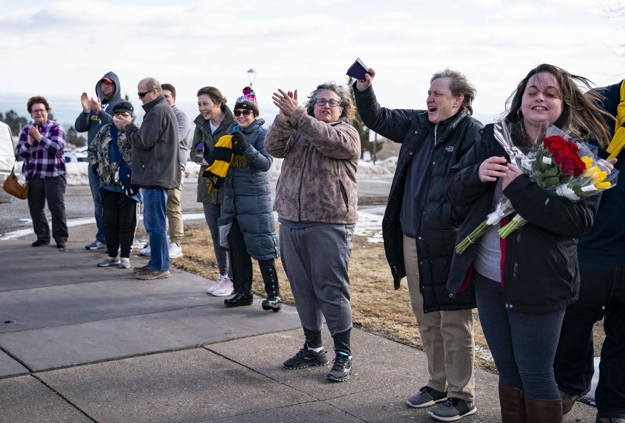 The Duluth Marshall girl's basketball team exited their bus to a line of applauding parents in the parking lot of their school after driving back from Minneapolis on Friday following the cancelation of the MSHL girl's basketball tournament.