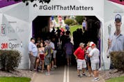 Fans gathered in a tunnel during a weather delay during the first round of the 3M Open in Blaine.