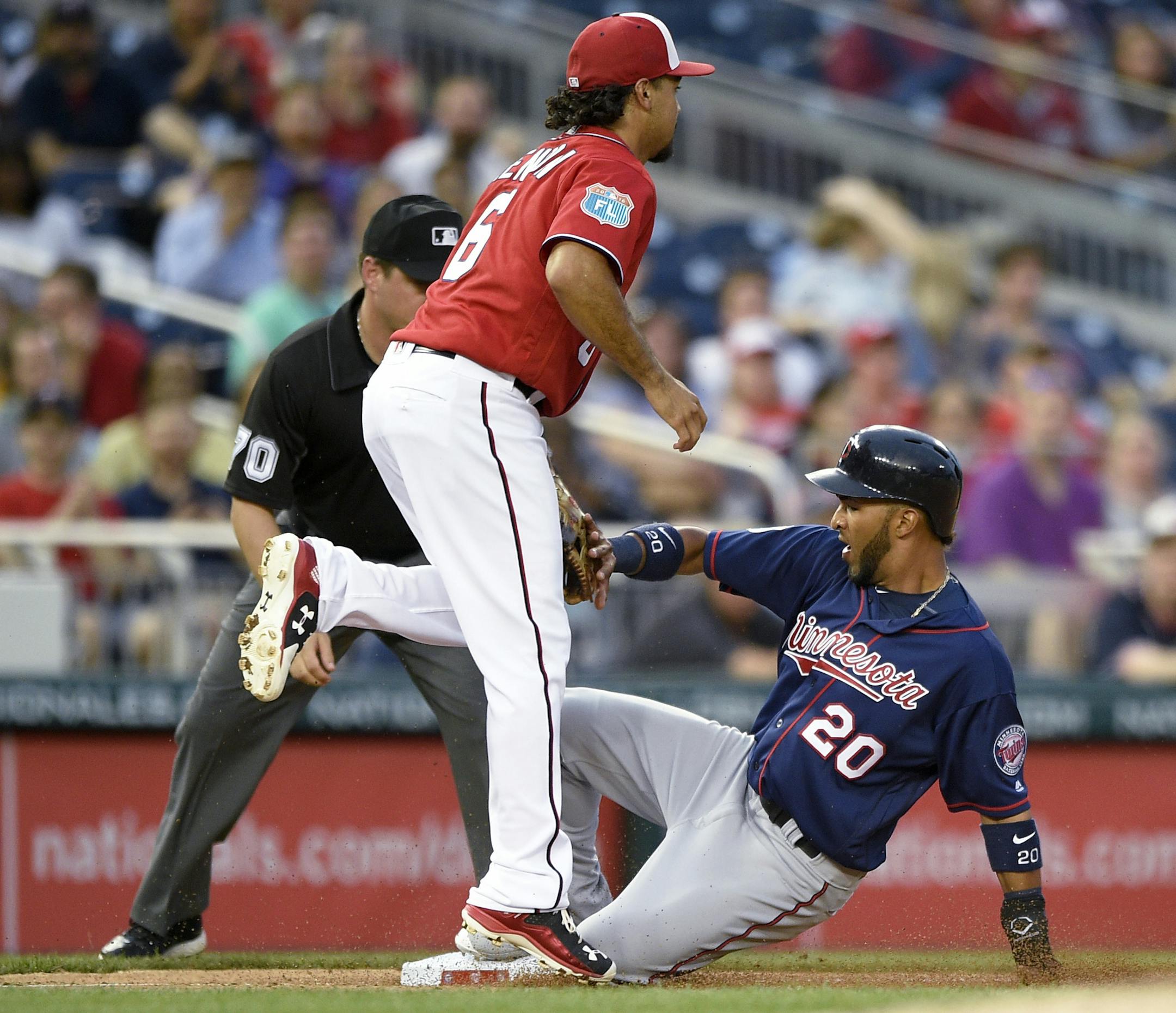 Minnesota Twins' Eddie Rosario (20) slides into third safely on a single by Byung Ho Park, next to Washington Nationals third baseman Anthony Rendon (6) during the fourth inning of an exhibition baseball game Friday, April 1, 2016, in Washington. The Nationals won 4-3. (AP Photo/Nick Wass)