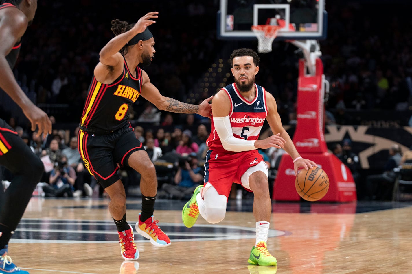 Washington Wizards' Tyus Jones (5) drives the ball as Atlanta Hawks' Patty Mills (8) tries to block during the first half of an NBA basketball game Sunday, Dec. 31, 2023, in Washington. (AP Photo/Jose Luis Magana)