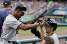 Minnesota Twins' Byron Buxton, left, is greeted in the dugout after hitting a solo home run during the fourth inning of a baseball game against the De