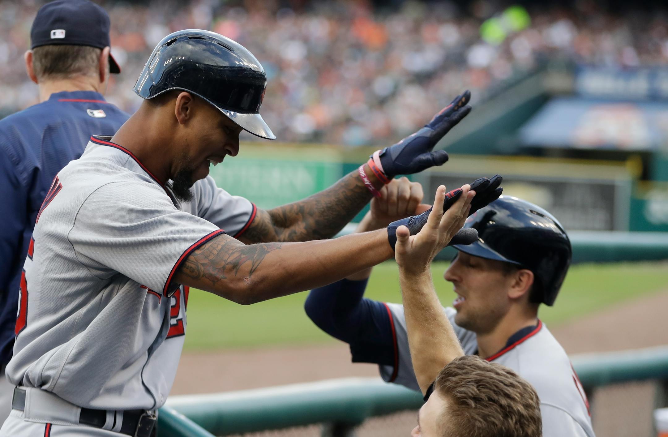 Minnesota Twins' Byron Buxton, left, is greeted in the dugout after hitting a solo home run during the fourth inning of a baseball game against the Detroit Tigers, Saturday, Aug. 12, 2017, in Detroit. (AP Photo/Carlos Osorio)