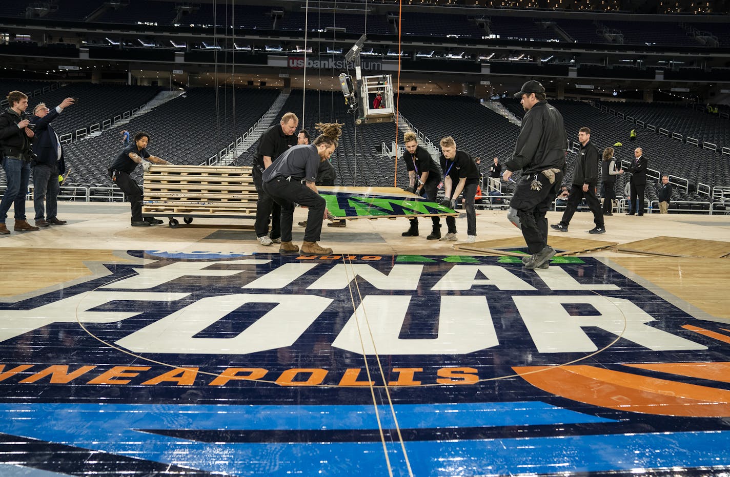 U.S. Bank Stadium operations workers install the court. ] LEILA NAVIDI &#xa5; leila.navidi@startribune.com BACKGROUND INFORMATION: Operations staff from U.S. Bank Stadium, along with supervision from Conor Sports technicians, installs the official 2019 NCAA Final Four court at U.S. Bank Stadium in Minneapolis on Friday, March 29, 2019. The court, built by Connor Sports, is a custom-built portable court made with maple wood sourced from sustainable forestry methods. The court is 70' x 140' and to