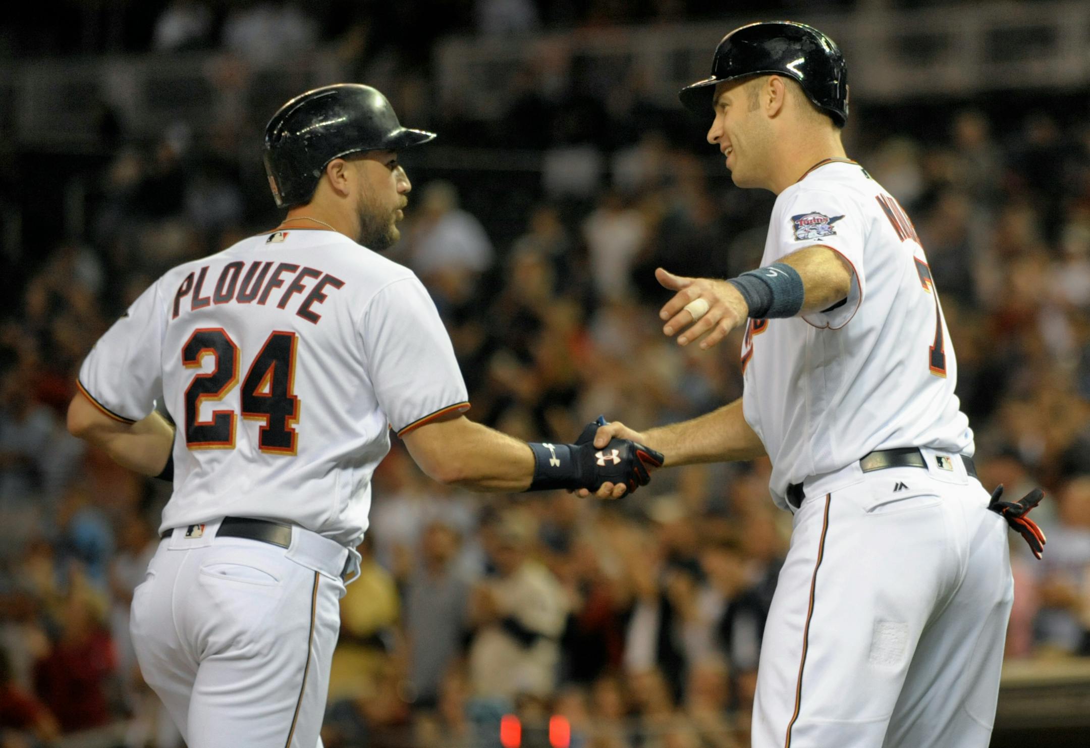 Minnesota Twins' Joe Mauer, right, congratulates Trevor Plouffe (24) after scoring on Pluouffe's two-run home run off Chicago White Sox pitcher Jose Quintana during the fifth inning of a baseball game, Thursday, Sept.. 1, 2016, in Minneapolis. (AP Photo/Tom Olmscheid)