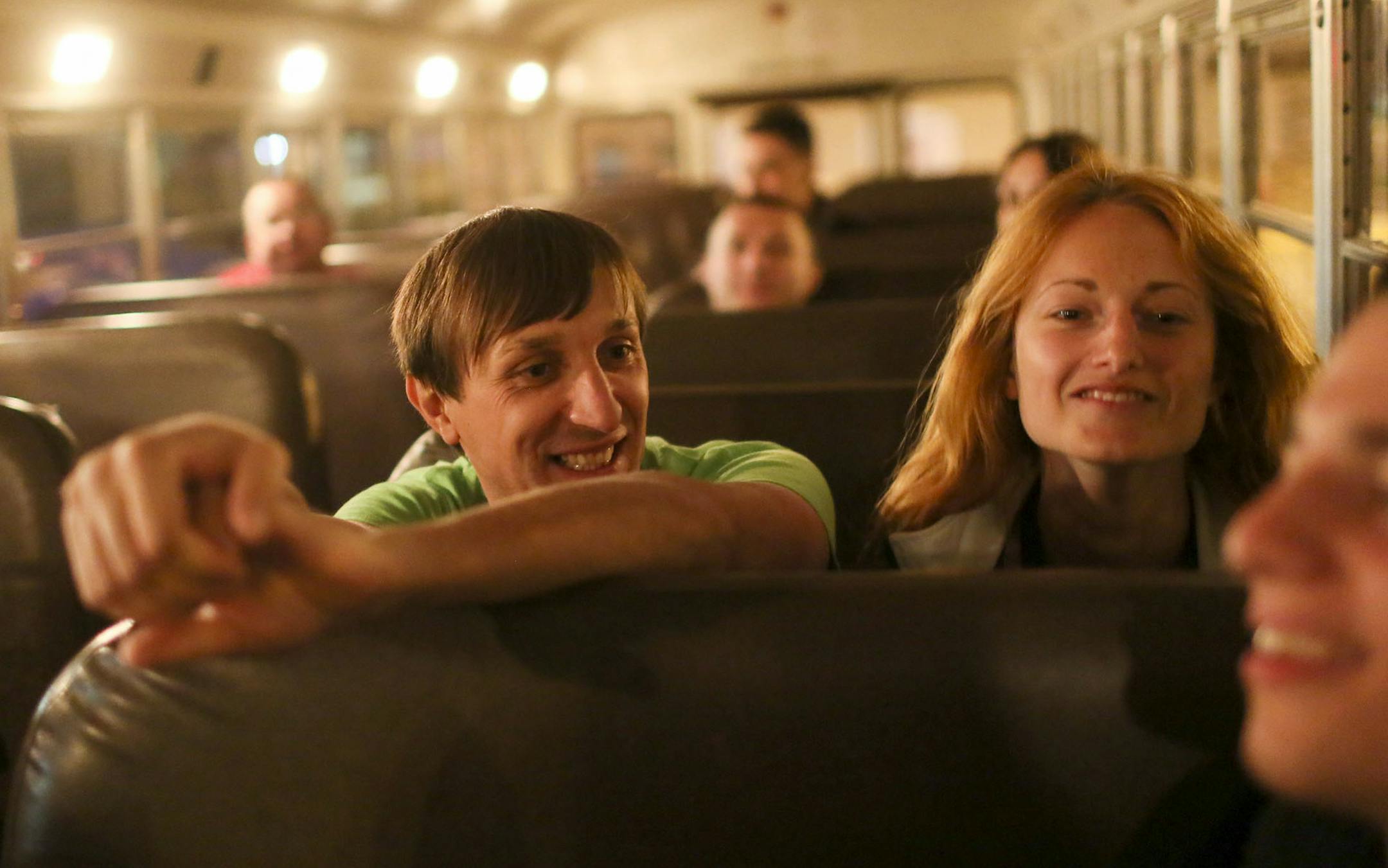A group of mostly Ukrainian workers have come to Perham this summer for employment at KLN Enterprises, the family-owned parent company of Barrel O' Fun that also manufactures snack brands for other companies. Here, after eating a late dinner at the Wadena VFW, Slav Makukha, center, and his girlfriend Karina Babaninasit, sit on a school bus before the start of a half hour ride that will take them to the temp jobs at KLN in Perham for the 11 p.m. shift Wednesday, July 16, 2014, in Wadena, MN.] (DA
