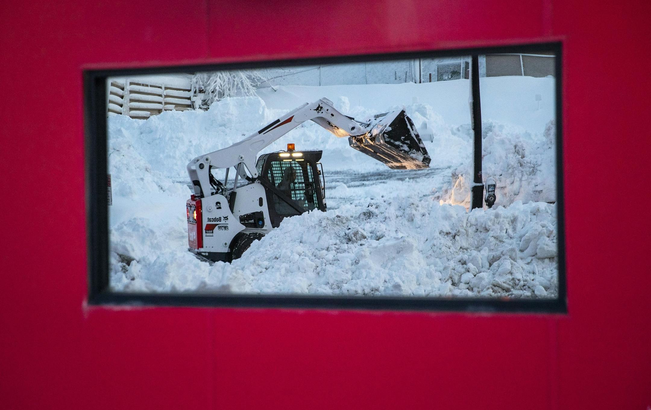 A small plow was reflected in a store window on First St. on Sunday afternoon.