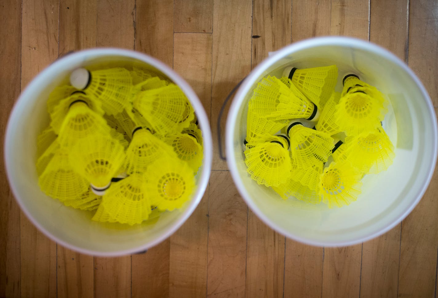 Buckets of badminton shuttlecocks are set aside during a team practice