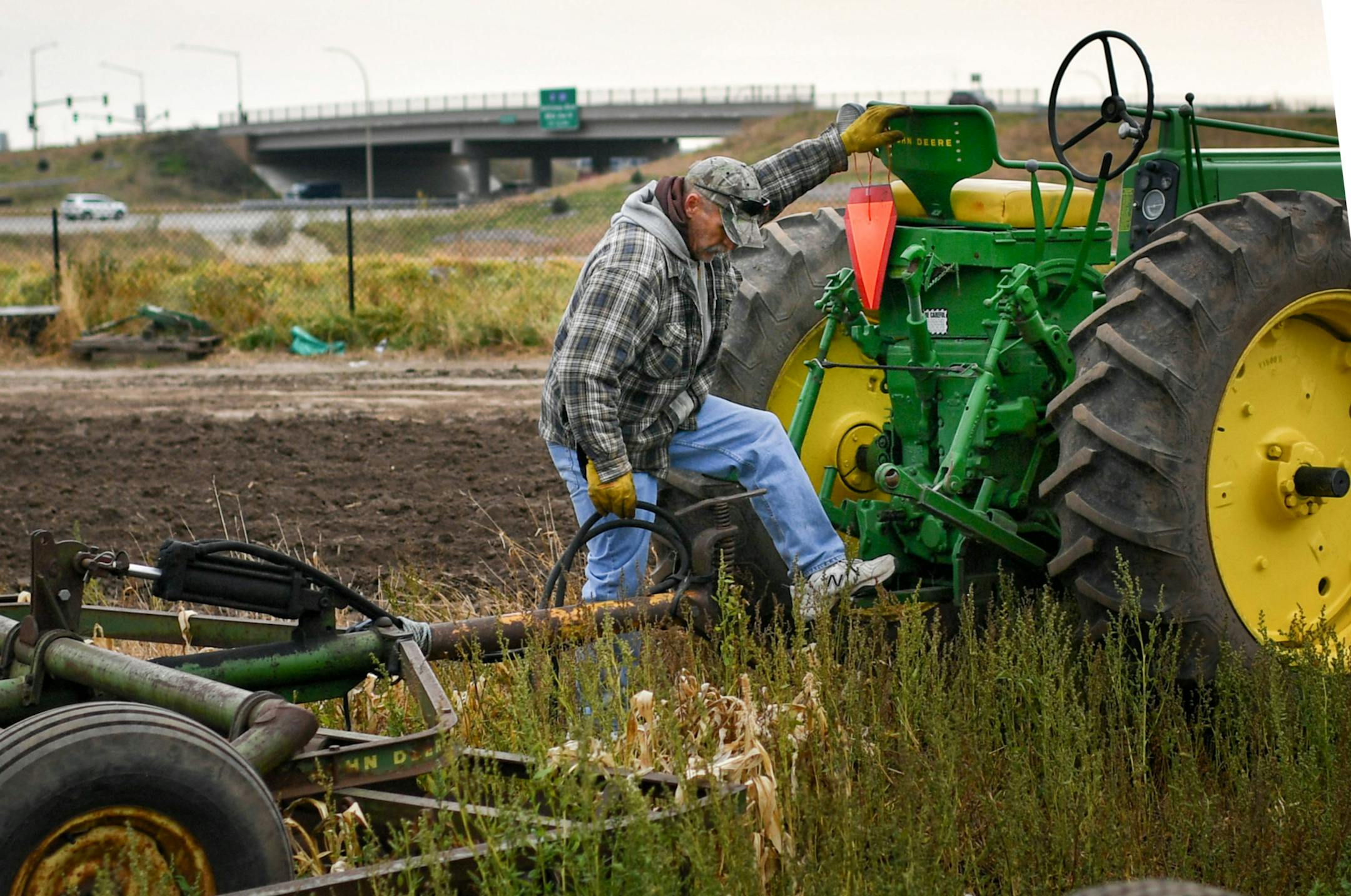 Charlie Fischbach's sweet corn farm is surrounded by roads and highways. He has to ride his tractor over a freshly installed curb and sidewalk. City planners didn't include curb cuts to allow for his or customer's access to his farm stand. ] GLEN STUBBE * gstubbe@startribune.com Thursday, November 17, 2016 this time: This is a profile story that will run later this month on the Fischbach family and the uncertain future of their popular sweet corn stand. To make way for new road developments, the