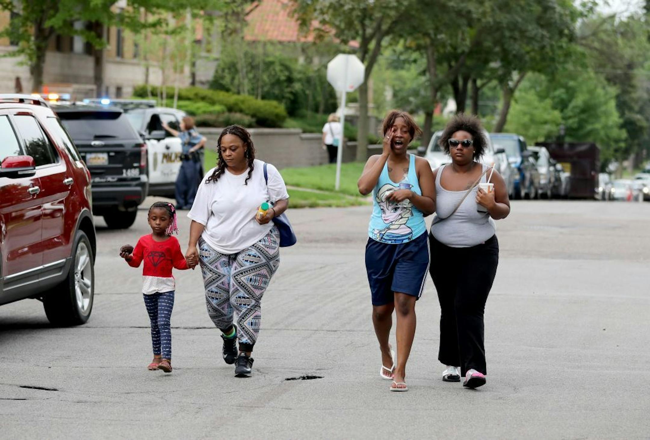 After visiting the protest site, Diamond Reynold, second from right, the girlfriend of Philando Castile, walks off with several unidentified comforters while yelling: "I want justice. I want peace," Thursday, July 7, 2016, in St. Paul, MN. Castile, 32, a St. Paul schools employee, was shot by a police officer following a traffic stop in Falcon Heights, MN. Castile later died Wednesday night at HCMC.