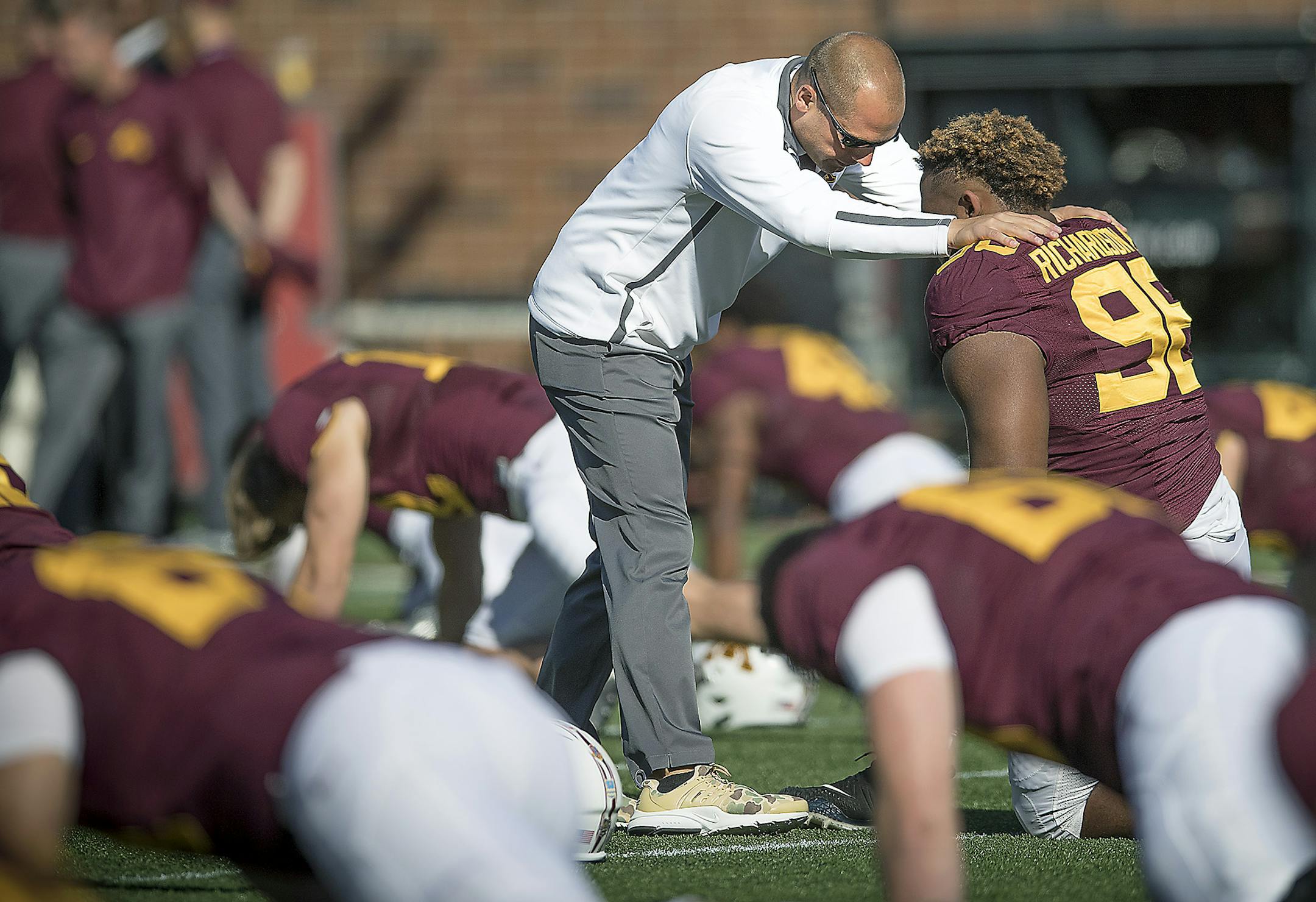 Minnesota coach P.J. Fleck chats with players, including defensive lineman Steven Richardson, during warm-ups before action against Maryland at TCF Bank Stadium